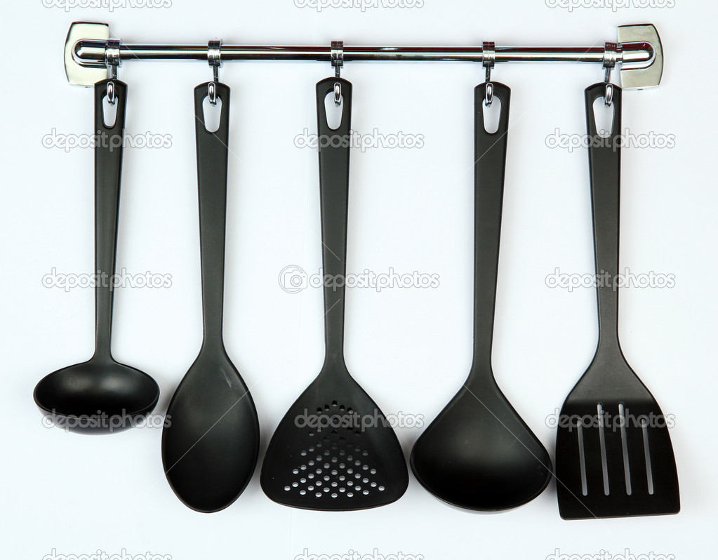 Black kitchen utensils on silver hooks, isolated on white — Stock Photo