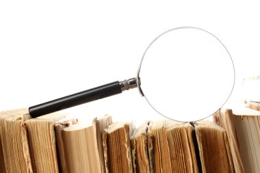 Büyüteç camı üzerinde beyaz izole kitap yığını üzerinde