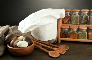 Şef'in şapkası ve kitchenwear tabloda gri arka plan üzerinde kompozisyonu