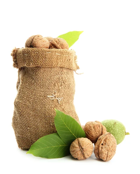 Walnuts with green leaves in burlap bag, isolated on white — Stock Photo, Image