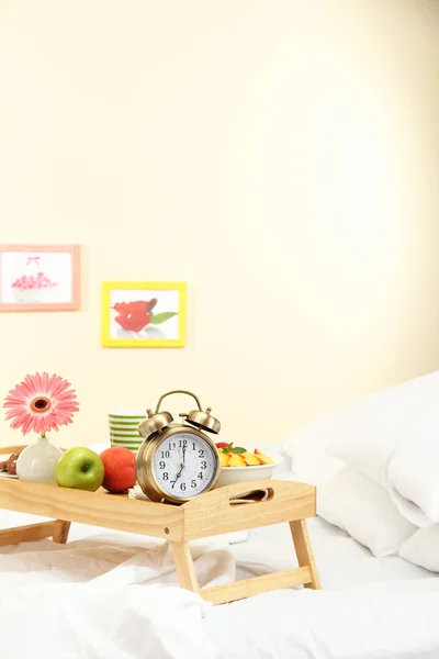 Wooden tray with light breakfast on bed — Stock Photo, Image