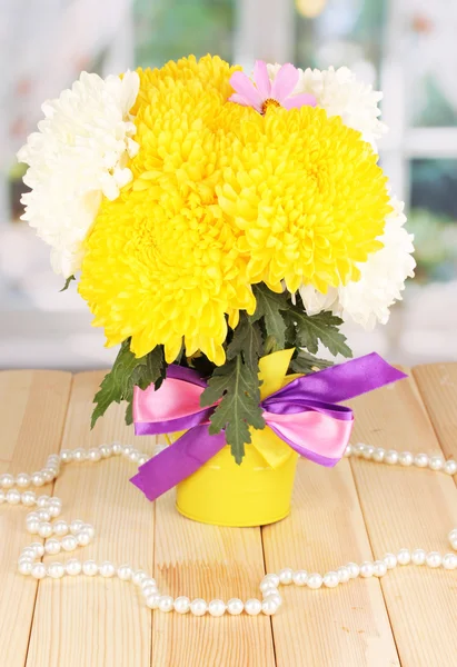 Mooie chrysant in emmer op houten tafel op achtergrond van venster — Stockfoto