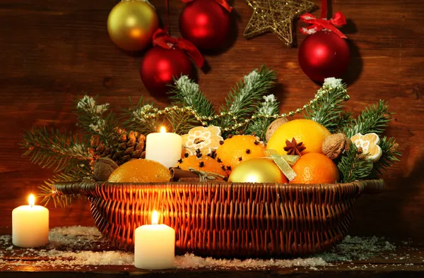 Composição de natal em cesta com laranjas e abeto, sobre fundo de madeira — Fotografia de Stock