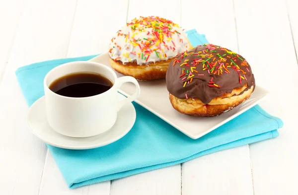 Leckere Donuts auf Farbteller auf hellem Holzhintergrund — Stockfoto