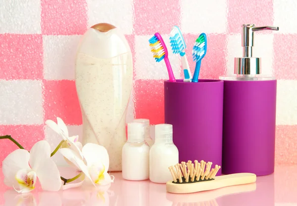 Bath accessories on shelf in bathroom on pink tile wall background — Stock Photo, Image