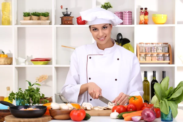 Young woman chef cooking in kitchen — Stock Photo, Image