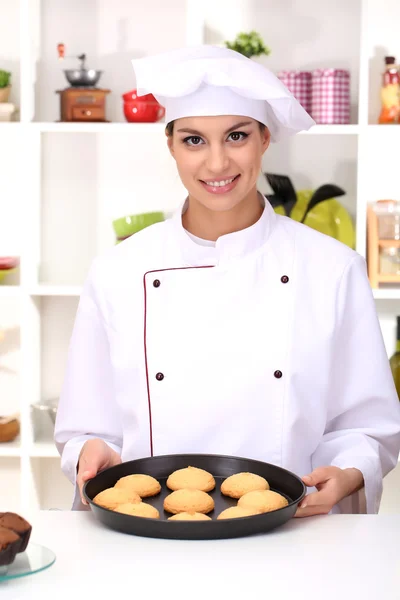 Junge Köchin mit Kuchen auf tropfnasser Pfanne in Küche — Stockfoto