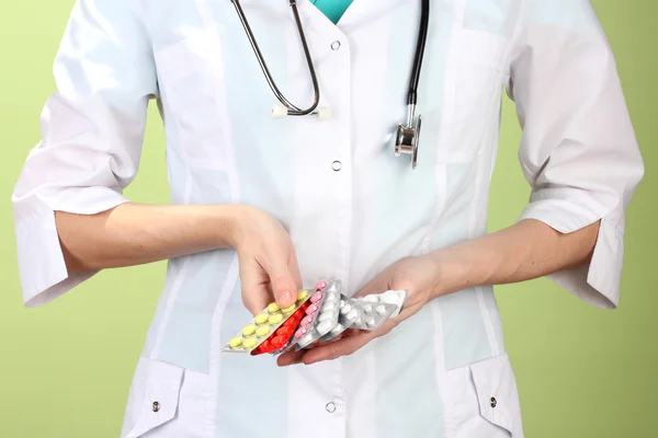 Kadın doktor el hapları, renkli arka plan üzerinde tutarak yakın çekim — Stok fotoğraf