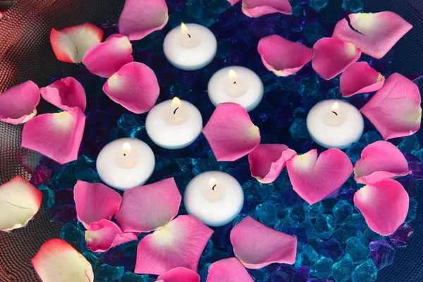 Płatki róż i świece w woda zbliżenie — Zdjęcie stockowe