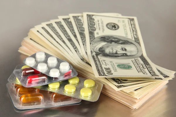 Pills and money on grey background — Stock Photo, Image