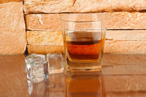 Viski ve buz üzerinde tuğla duvar arka cam — Stok fotoğraf