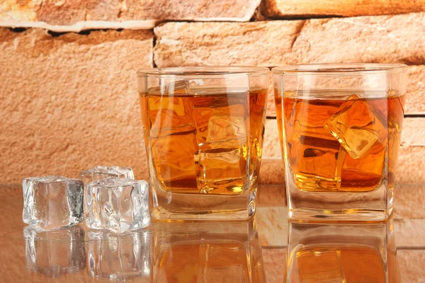 Vasos de whisky y hielo sobre fondo de pared de ladrillo —  Fotos de Stock