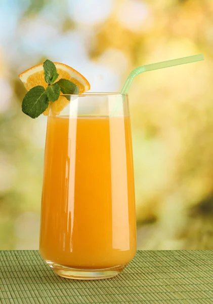 Copo de suco de laranja com hortelã na mesa em fundo brilhante — Fotografia de Stock