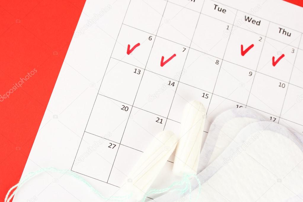 menstruation calendar with sanitary pads and tampons, close-up