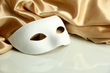 Beyaz maske ve altın ipek kumaş üzerine beyaz izole,