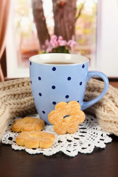 Xícara de chá com cachecol na mesa no quarto — Fotografia de Stock
