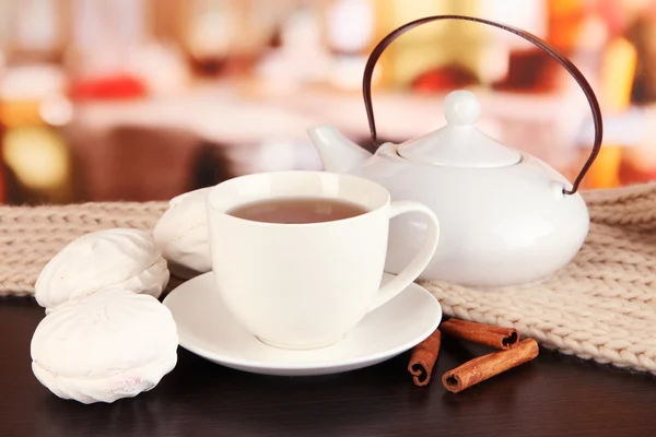 Cup of tea with scarf on table in room — Stock Photo, Image