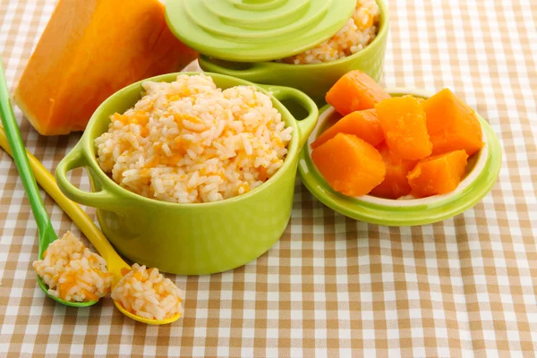 Taste rice porridge with pumpkin in saucepans on tablecloth background — Stock Photo, Image