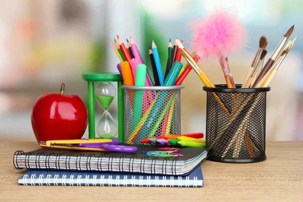 Material escolar con manzana sobre mesa de madera —  Fotos de Stock