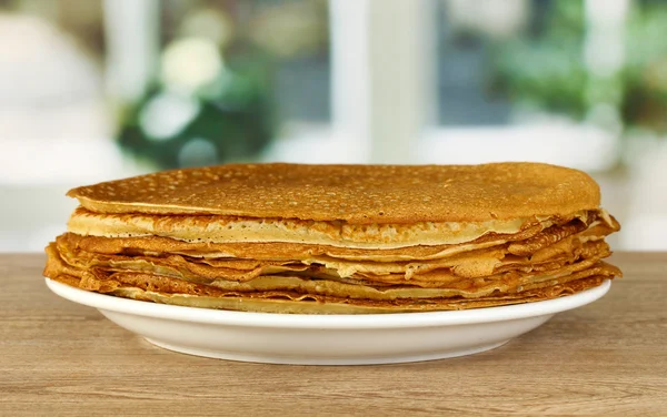 Sweet pancakes on plate on table in kitchen — Stock Photo, Image