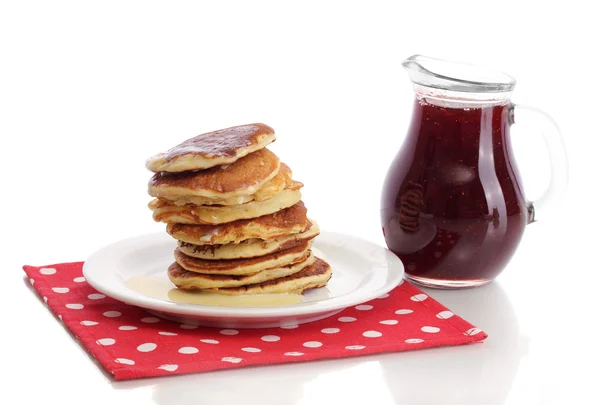 Sweet pancakes on plate with condensed milk isolated on white — Stock Photo, Image