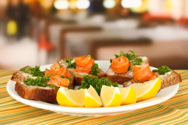 Сендвіч лосося на тарілці, на яскравому фоні — стокове фото