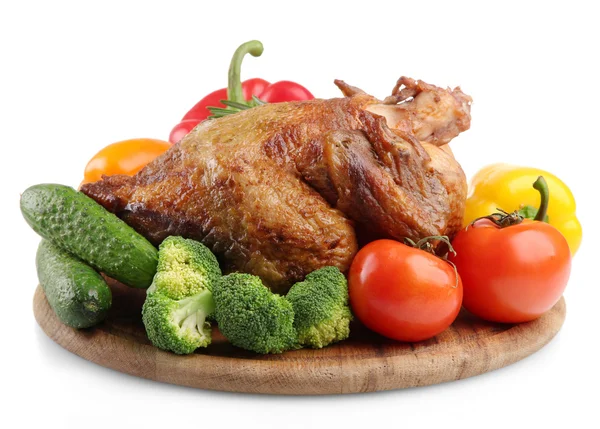Целый жареный цыпленок на деревянной тарелке с овощами, изолированные на белом — стоковое фото