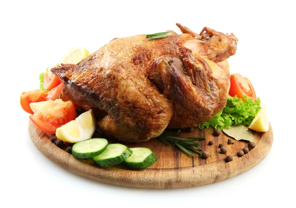Whole roasted chicken on wooden plate with vegetables, isolated on white — Stock Photo, Image