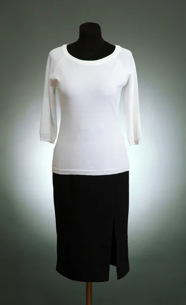 Białą bluzkę i czarną spódnicę na manekin na szarym tle — Zdjęcie stockowe