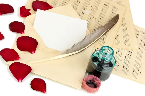 Vieille enveloppe avec papier blanc et pétales de rose séchés sur des feuilles de musique close up — Photo