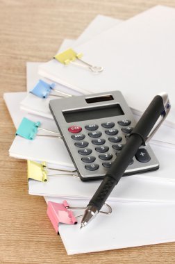 ahşap masa üzerinde bağlayıcı klipleri içeren belgeler