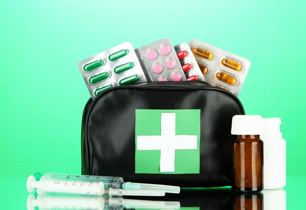 Bolsa de primeros auxilios, sobre fondo verde —  Fotos de Stock