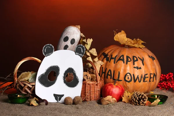Trick or treat halloween masks and bucket filled with cookies on color background — Stock Photo, Image