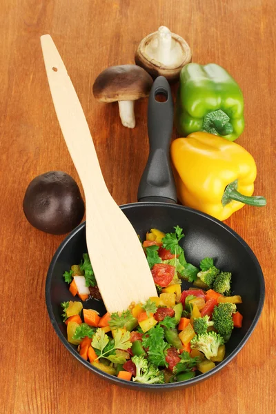 Verdure fresche affettate in padella sul tavolo di legno — Foto Stock