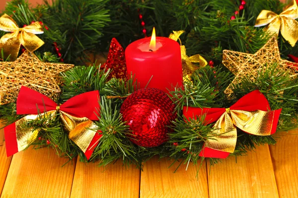 Christmas composition with candle and decorations in red and gold colors on wooden background — Stock Photo, Image