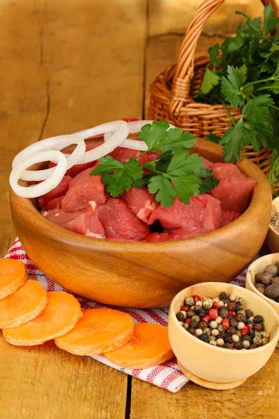 Raw beef meat with herbs and spices on wooden table on brown background — Stock Photo, Image