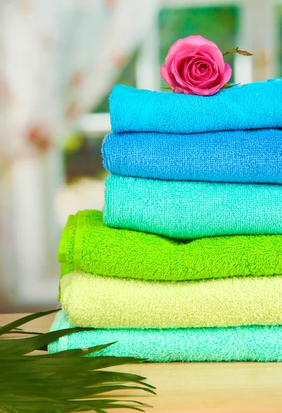 Stack of towels with fragrant flower on window background — Stock Photo, Image