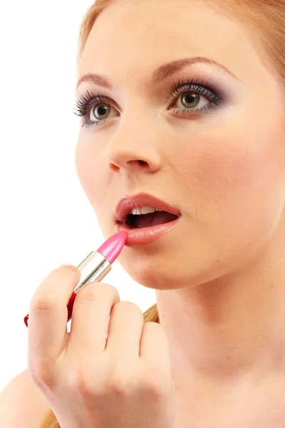 Schöne junge Frau, die Lipgloss aufträgt, isoliert auf Weiß — Stockfoto