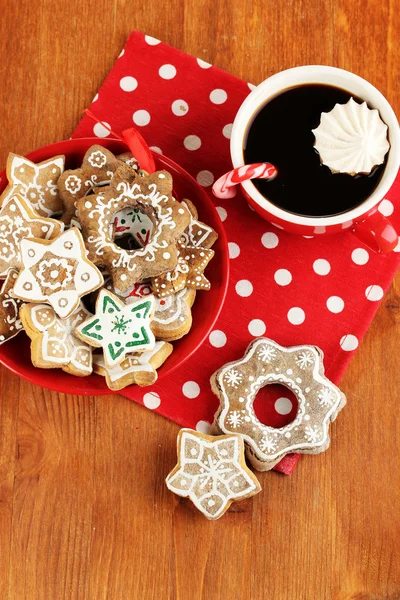 Weihnachtsleckereien auf Teller und Tasse Kaffee auf Holztisch in Großaufnahme — Stockfoto
