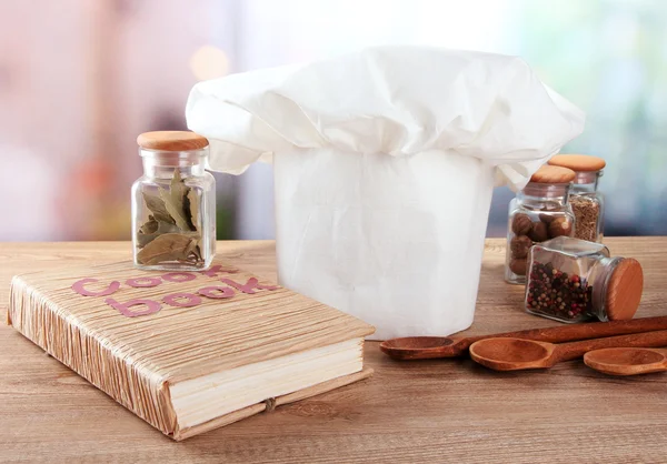 Chef's hat with spoons on table in kitchen — Stock Photo, Image