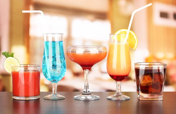 Several glasses of different drinks on bright background — Stock Photo, Image