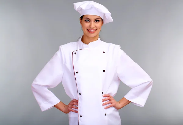 Портрет молодої жінки шеф-кухаря на сірому фоні — стокове фото