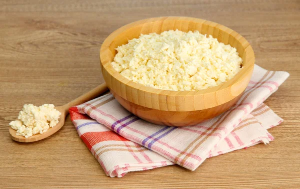 Cottage cheese in bowl on wooden table — Stock Photo, Image