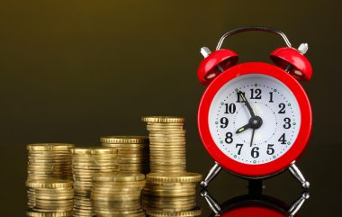 koyu arka plan üzerinde paralar ile çalar saat