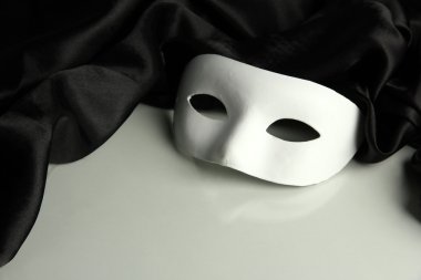Beyaz maske ve siyah ipek kumaş üzerine beyaz izole,