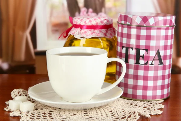Tarro y taza de té en la mesa en la habitación —  Fotos de Stock