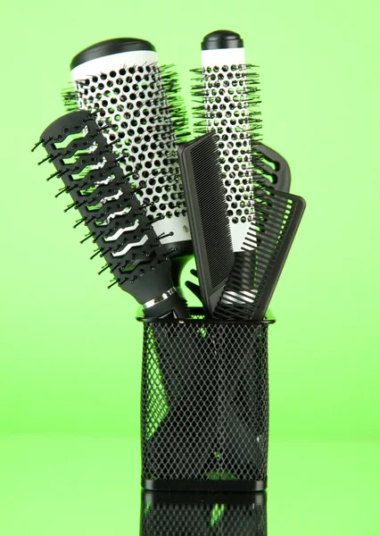 Eisenkorb mit Kämmen und runden Haarbürsten, auf farbigem Hintergrund — Stockfoto