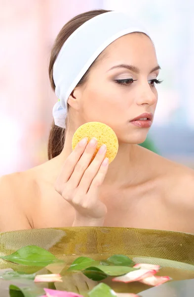 Young woman washing her face. Conceptual photo: make-up remover