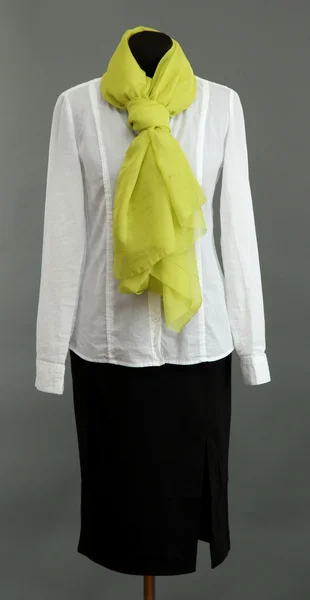 Witte blouse, zwarte rok en groene sjaal op etalagepop op grijze achtergrond — Stockfoto