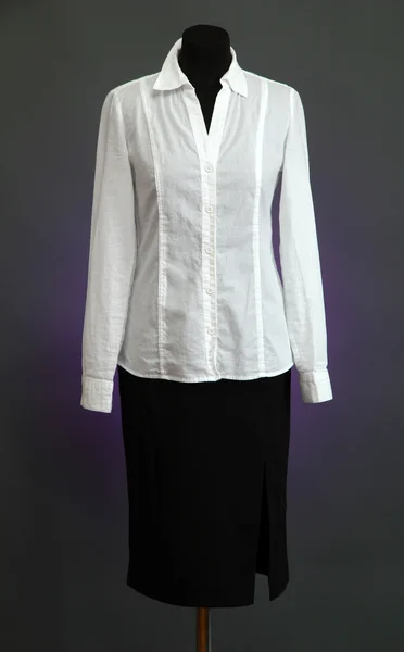 Белая блузка и черная юбка с пальто на манекене на цветном фоне — стоковое фото